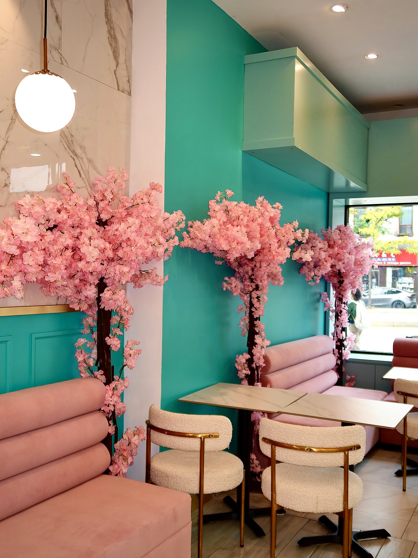 Pink banquettes and blossom decorations inside Puuffy Bakery & Ice Cream — official venue photo
