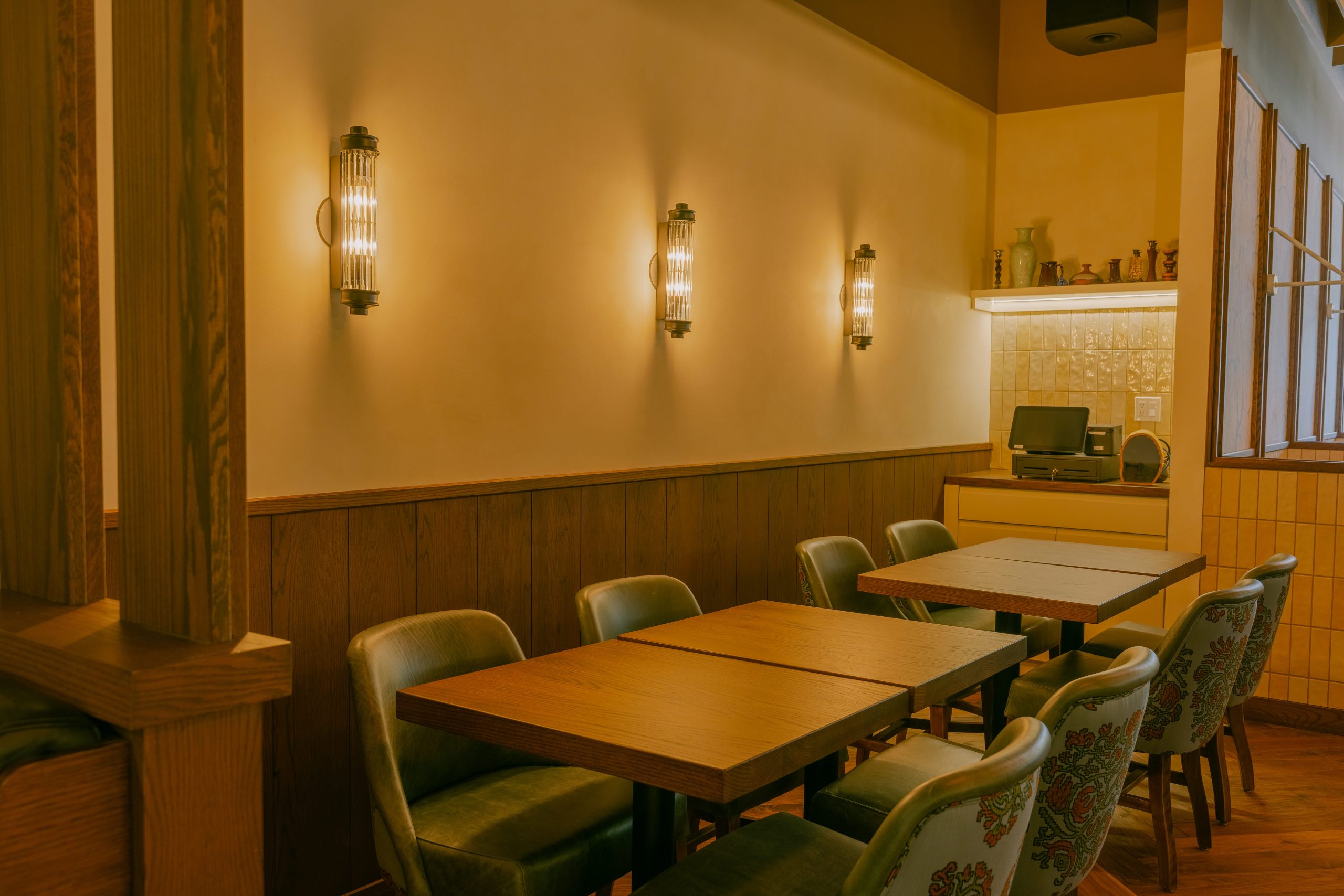 Warmly lit dining room with wood panelling and upholstered chairs at Woodlyns — official venue photo