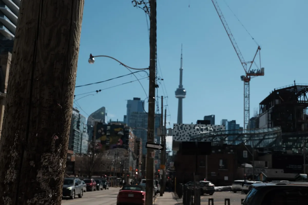 Construction cranes tower over the Toronto skyline beside the CN Tower