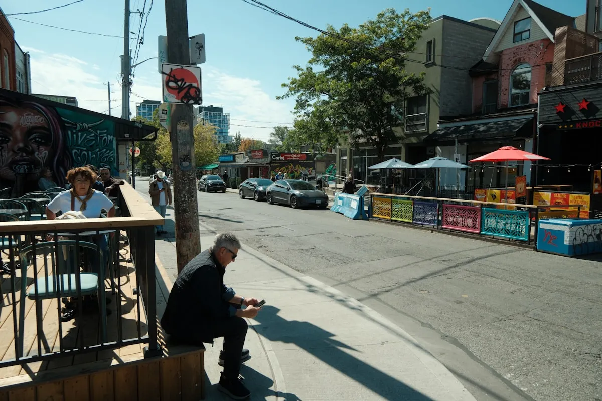 People sitting at an outdoor cafe on a sunny Toronto street