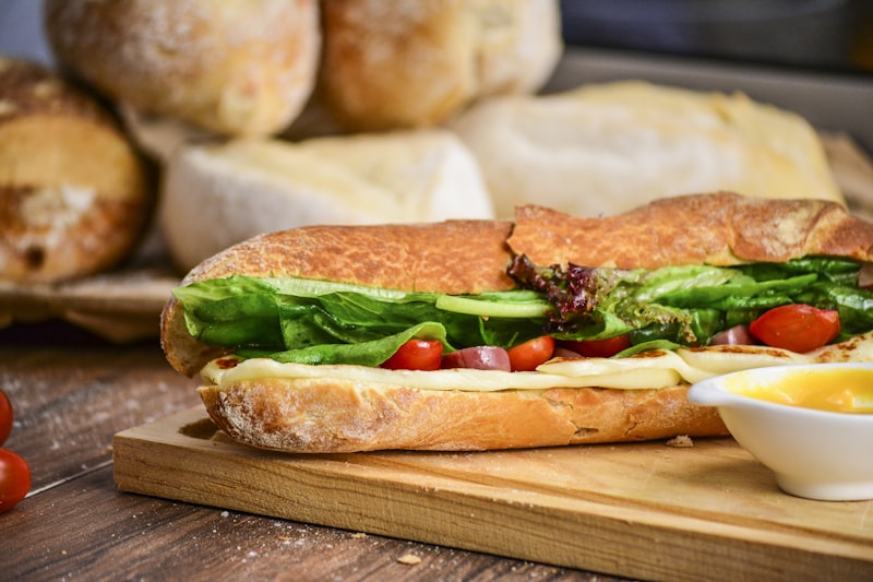 Stacked deli sandwich with fresh ingredients on rustic counter