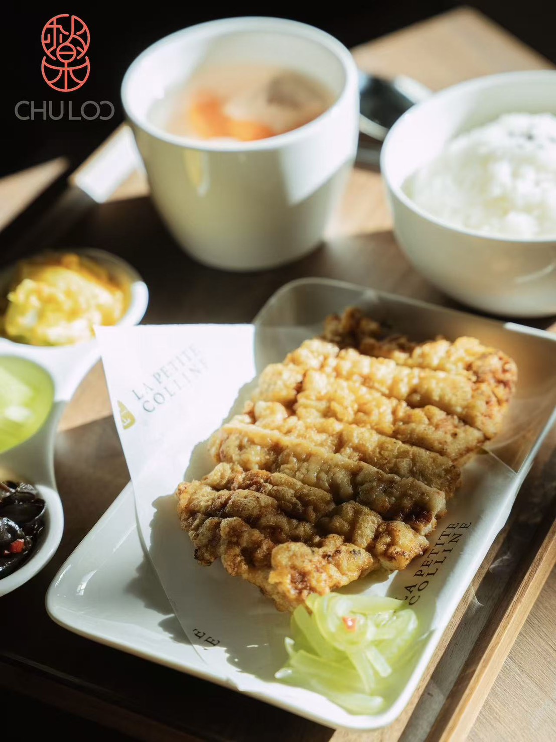 Chu Loo / La Petite Colline set meal: fried cutlet, rice, soup, and pickles on branded parchment — venue-posted Google photo