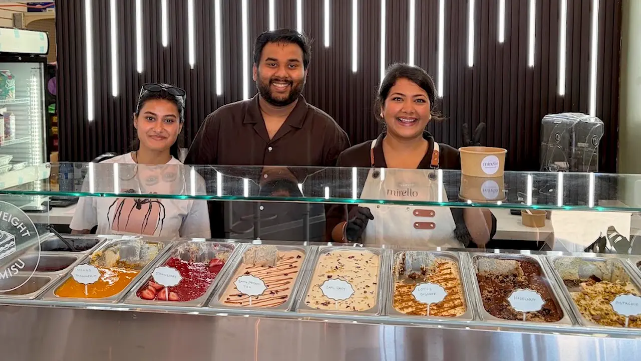 Mirello staff behind the pay-by-weight tiramisu well at 60 Danforth Road, flavour pans labelled in the case