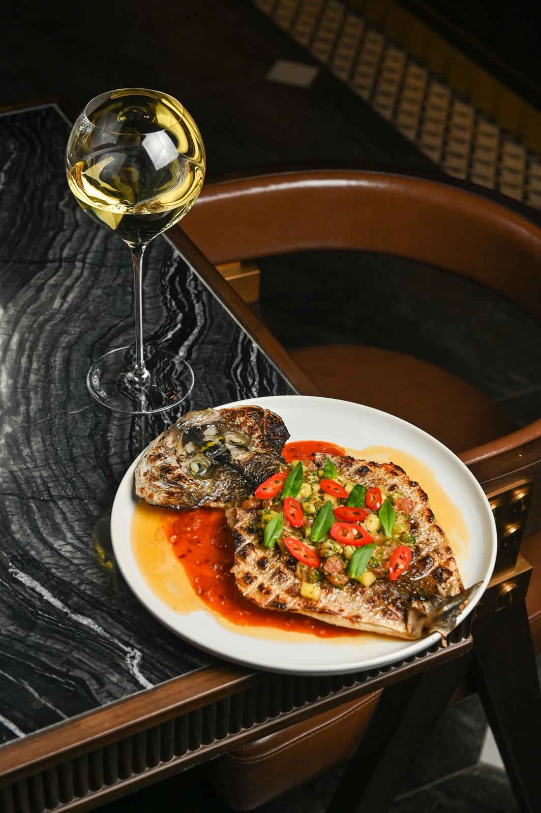 Grilled whole sea bream with chili-herb salsa and white wine at Petite Lune, 31 Baldwin — official photo from petitelune.ca