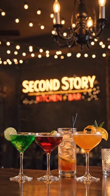 Cocktails on the bar under a Second Story Kitchen and Bar neon, from the venue Instagram