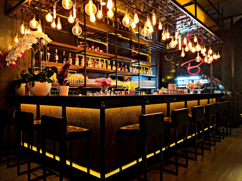Moody cocktail bar interior with warm lighting and sleek onyx bar