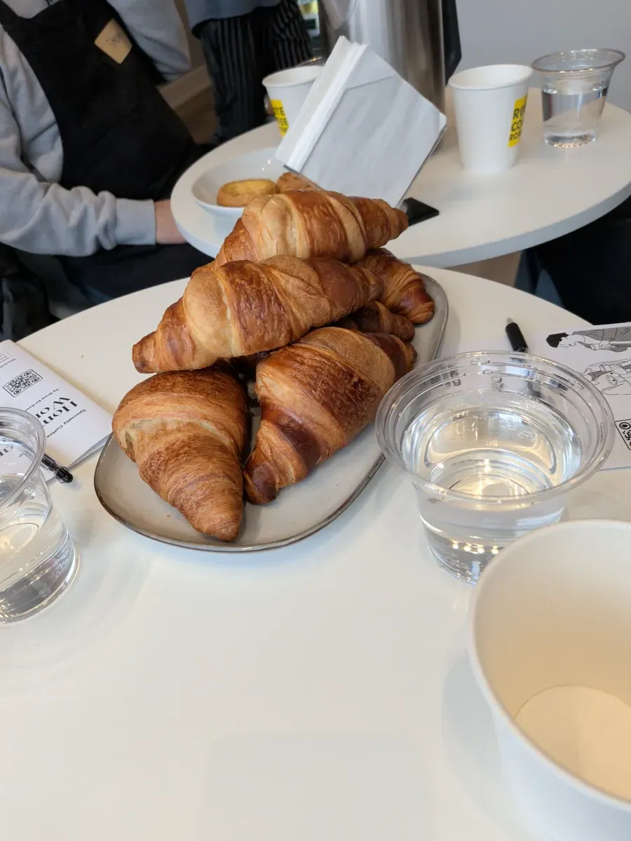 A plate of golden, flaky croissants sitting on a white table during the workshop