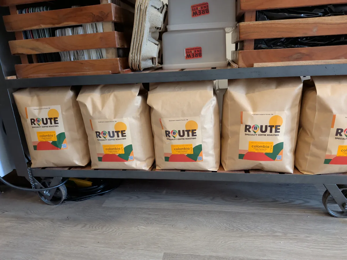 Several large bags of Route Coffee Roasters beans on a metal rack