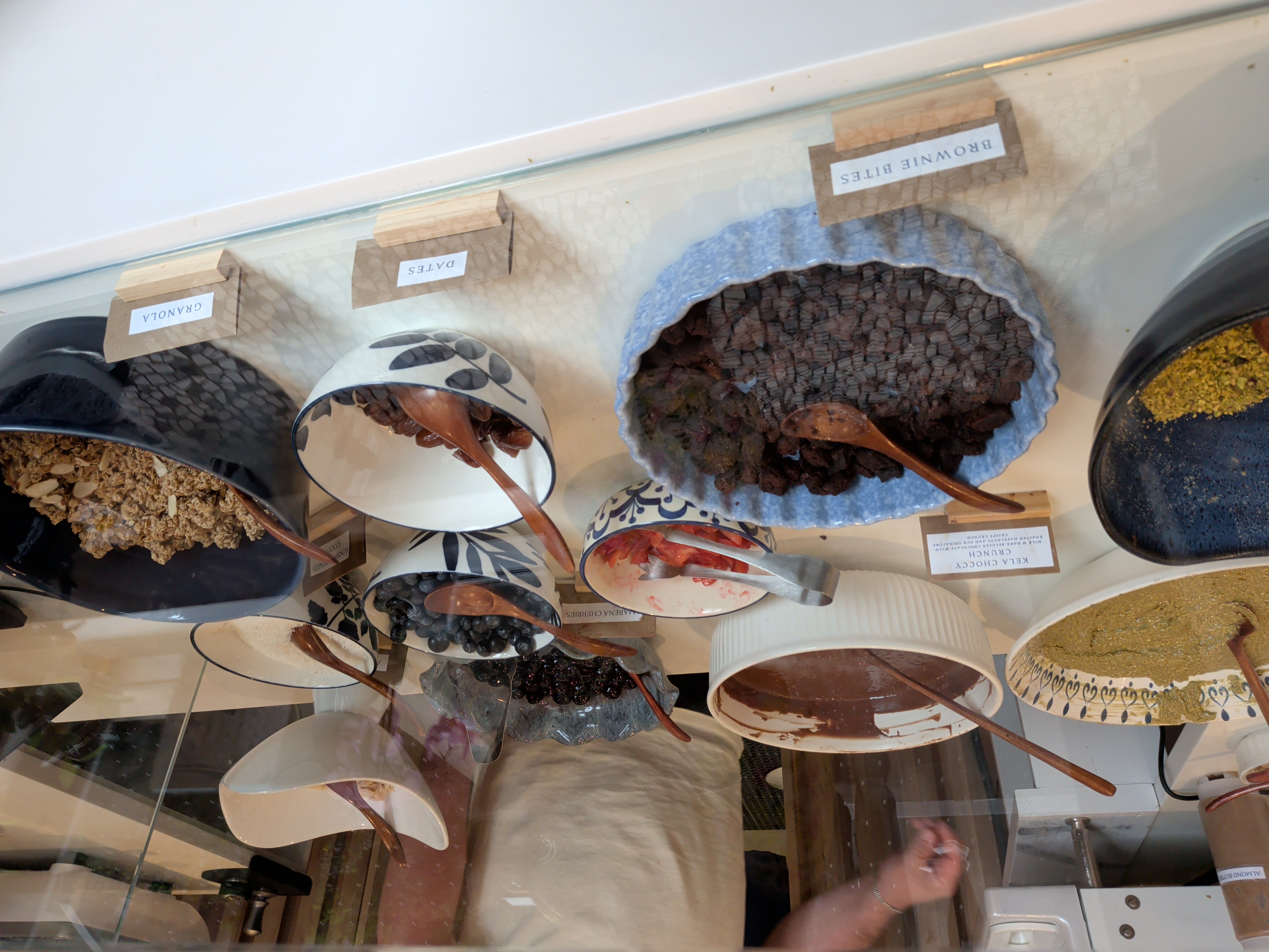 Display bowls featuring various toppings like brownie bites, dates, and granola