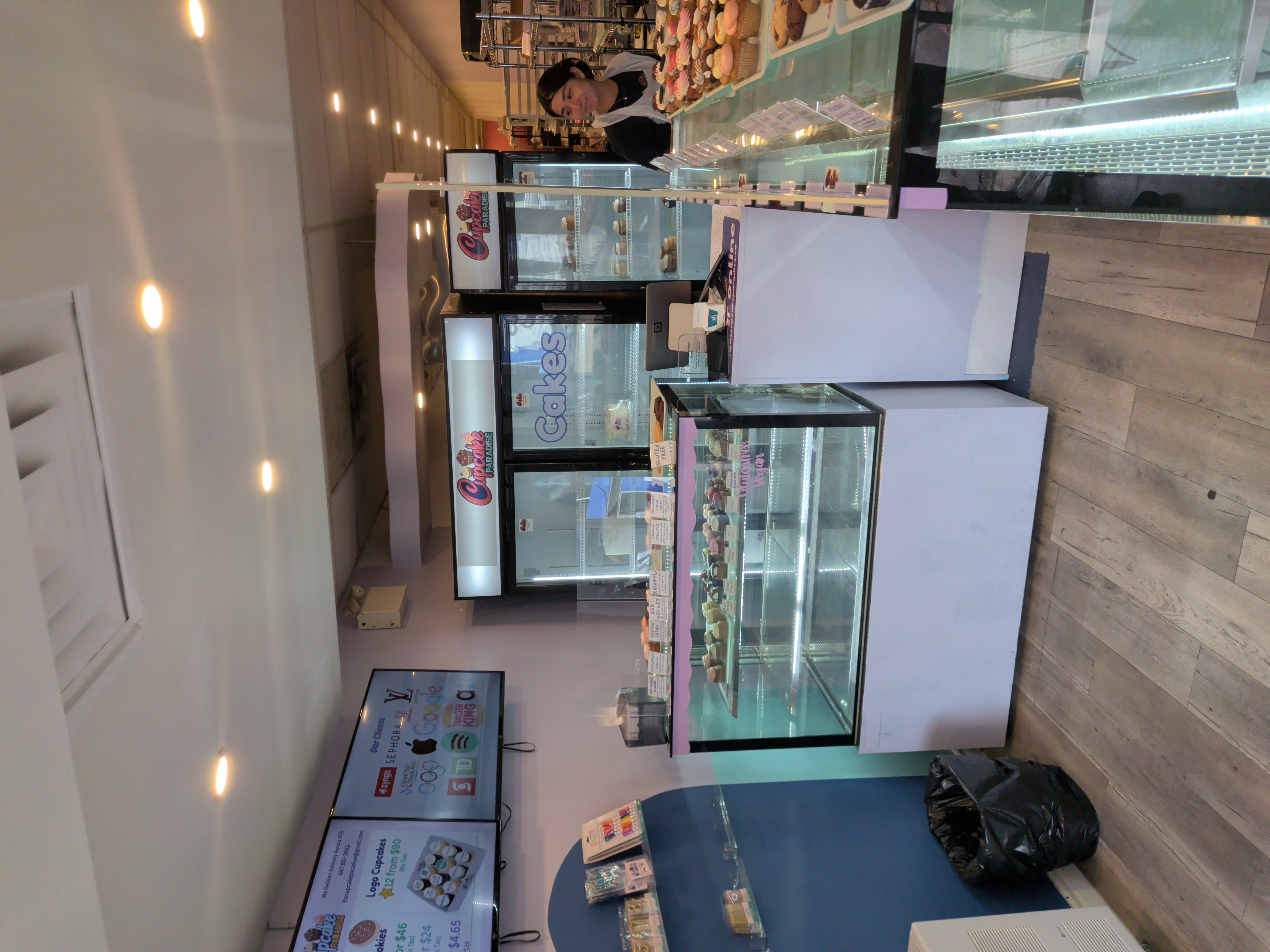 Interior view of Cupcake Paradise featuring the display counter and fridges