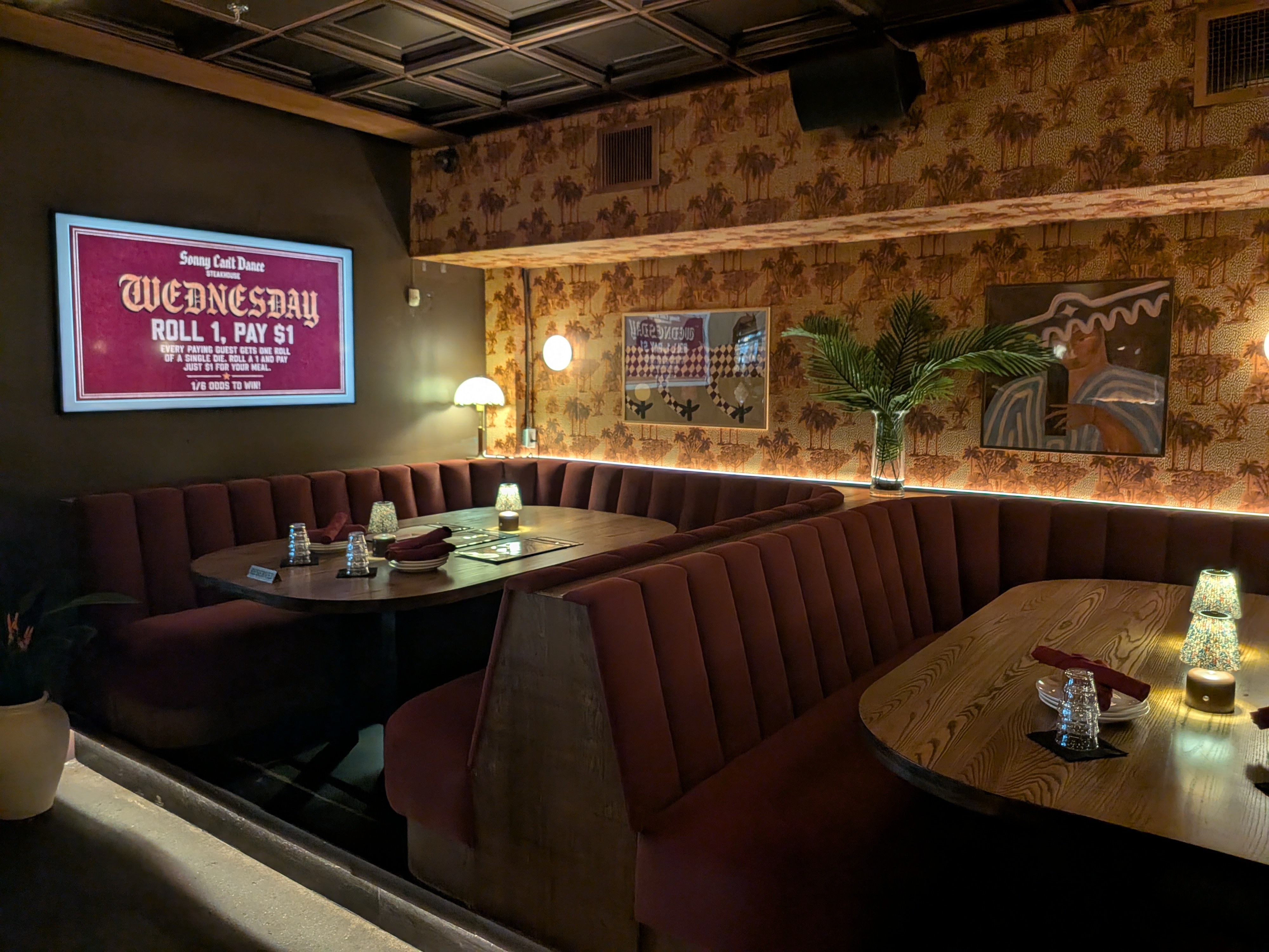 Maroon booths and the Wednesday Dice Night sign at Sonny Can't Dance on King West