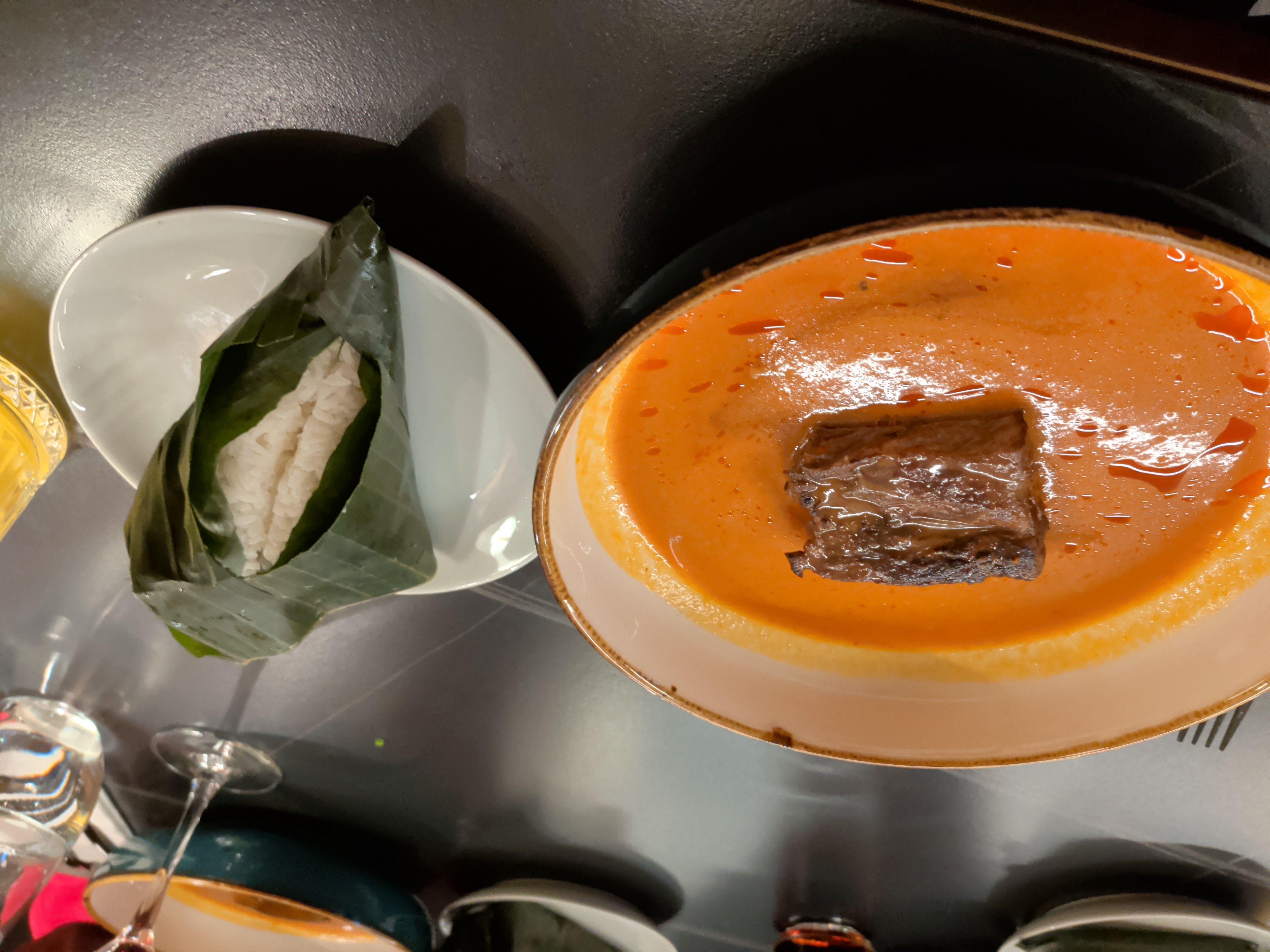 A meat dish served in a bright orange curry sauce