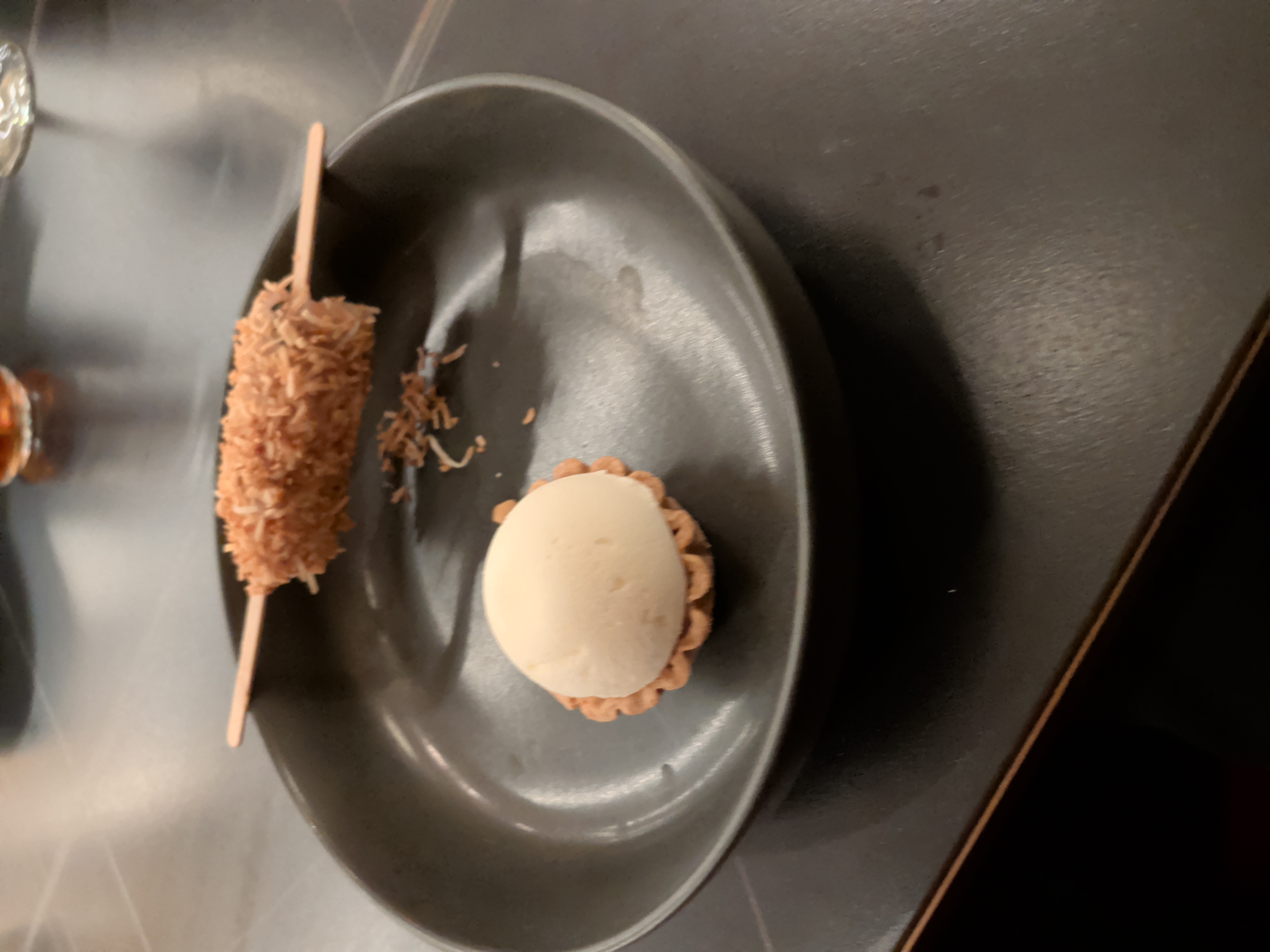 A small dessert tart and a coconut-covered skewer