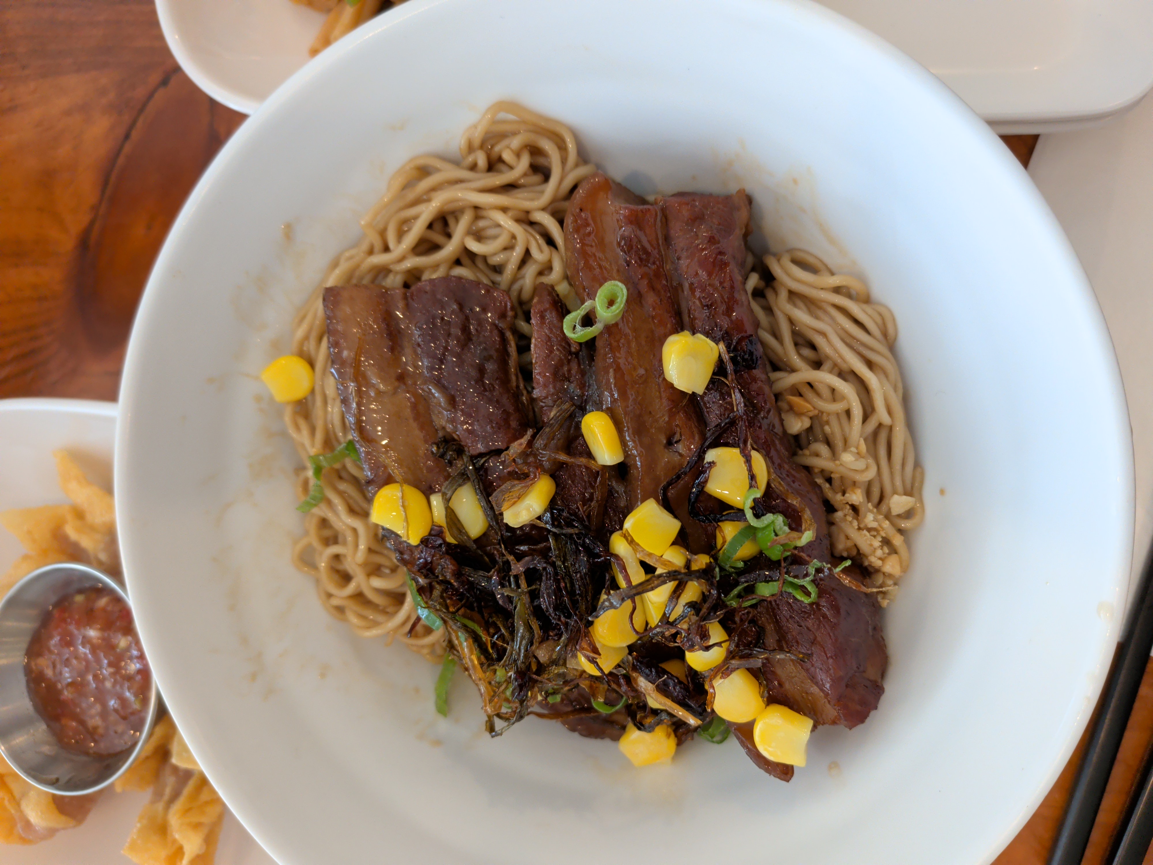 Dry noodles with two slices of glazed braised pork belly