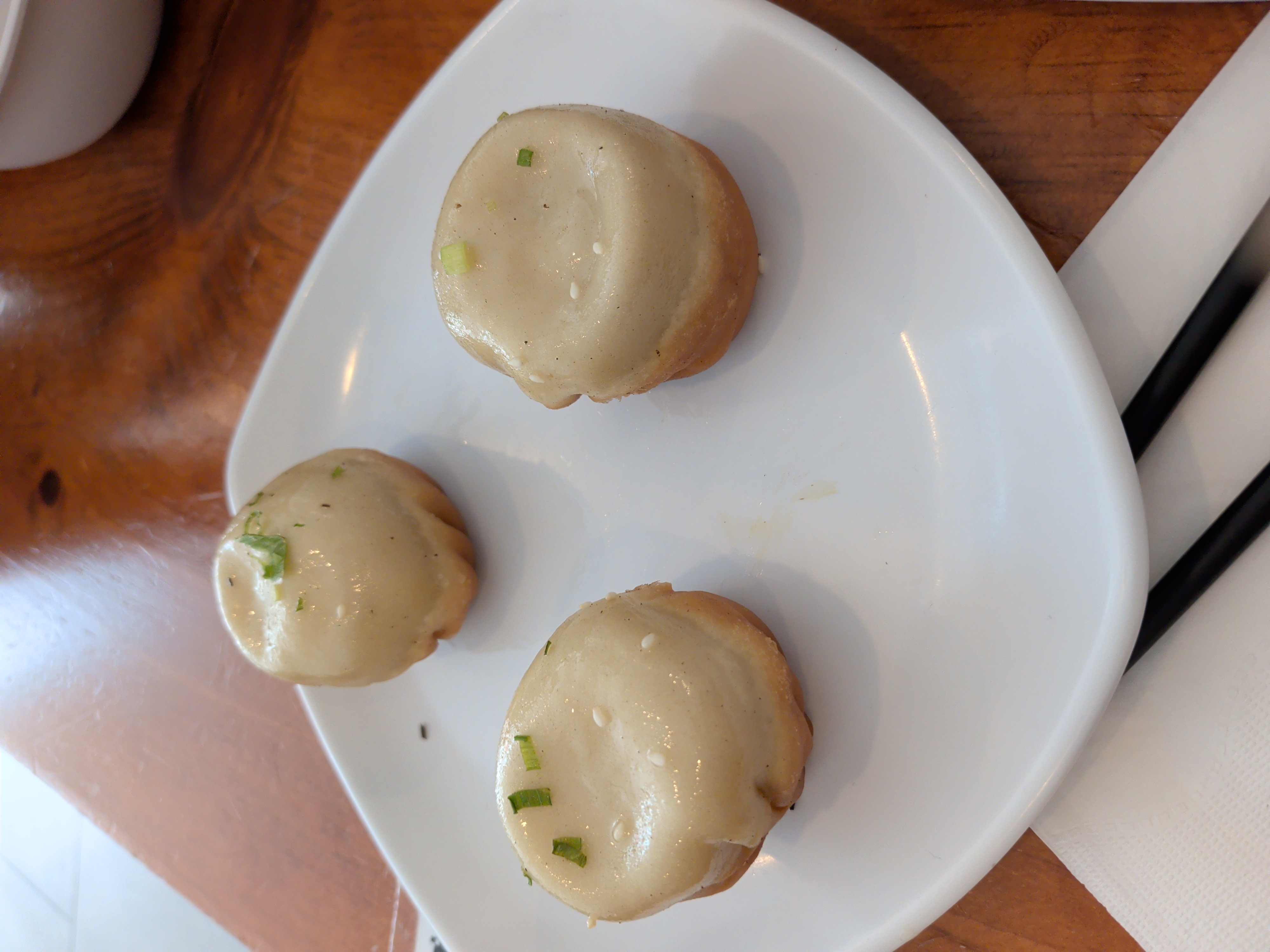 Original pork sheng jian bao with sesame, scallion, and a fried golden skirt