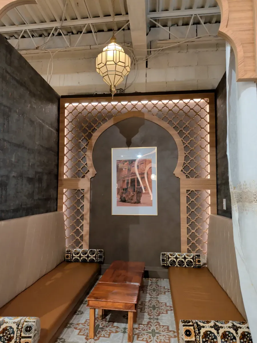 A cozy, well-lit booth seating area with cushioned benches and decorative lattice-work.